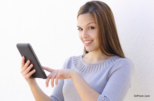 Beautiful woman holding a tablet reader and looking at camera